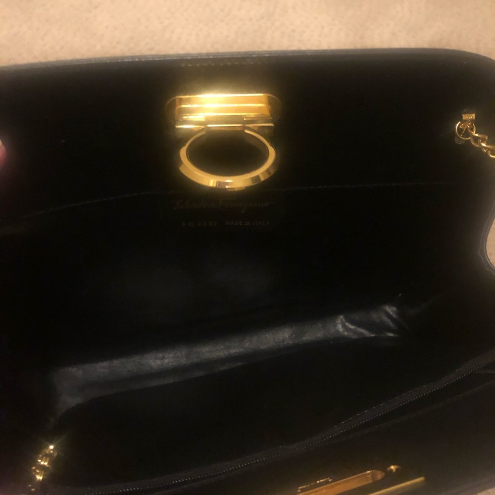 Feeragamo black clutch with gold chain strap. The authenticity stamp inside.